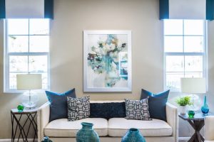 A modern living room with beige couch and navy throw pillows 