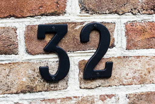 Black house numbers on a brick home 